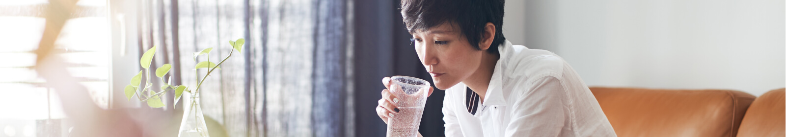 a woman working on her laptop drinking water